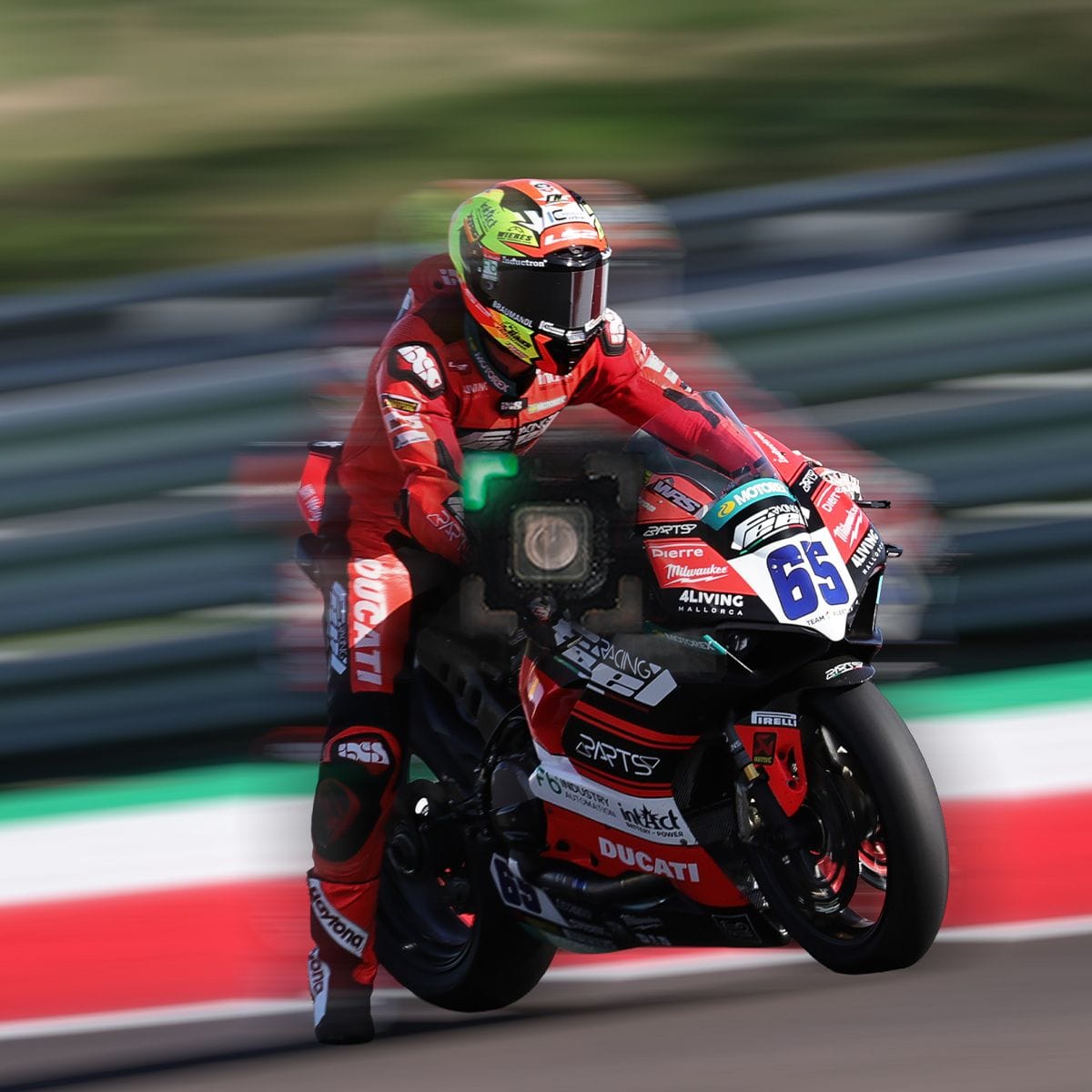 Motorcycle racer in red suit on black bike number 65 on a blurred track.