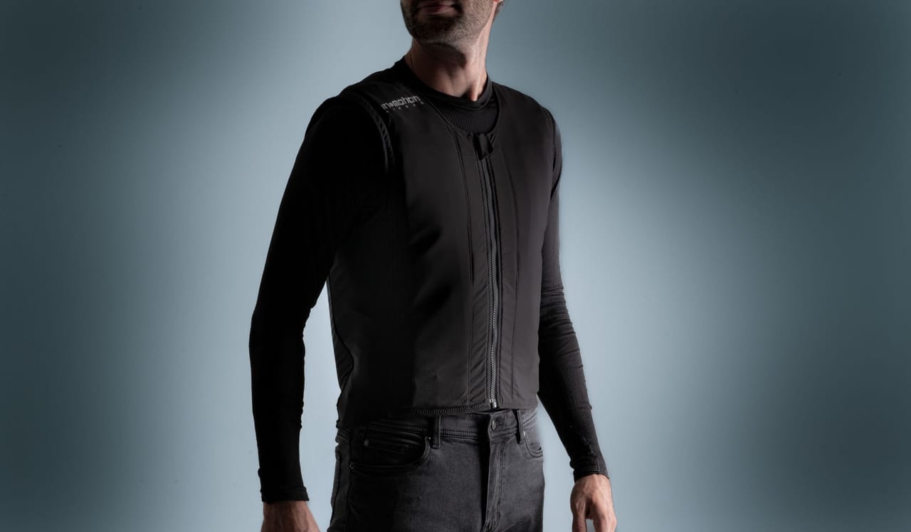 Man wearing a black protective vest over a long-sleeved shirt.